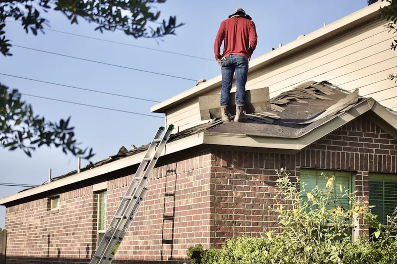 Professional roofer working on a residential roof in Tea